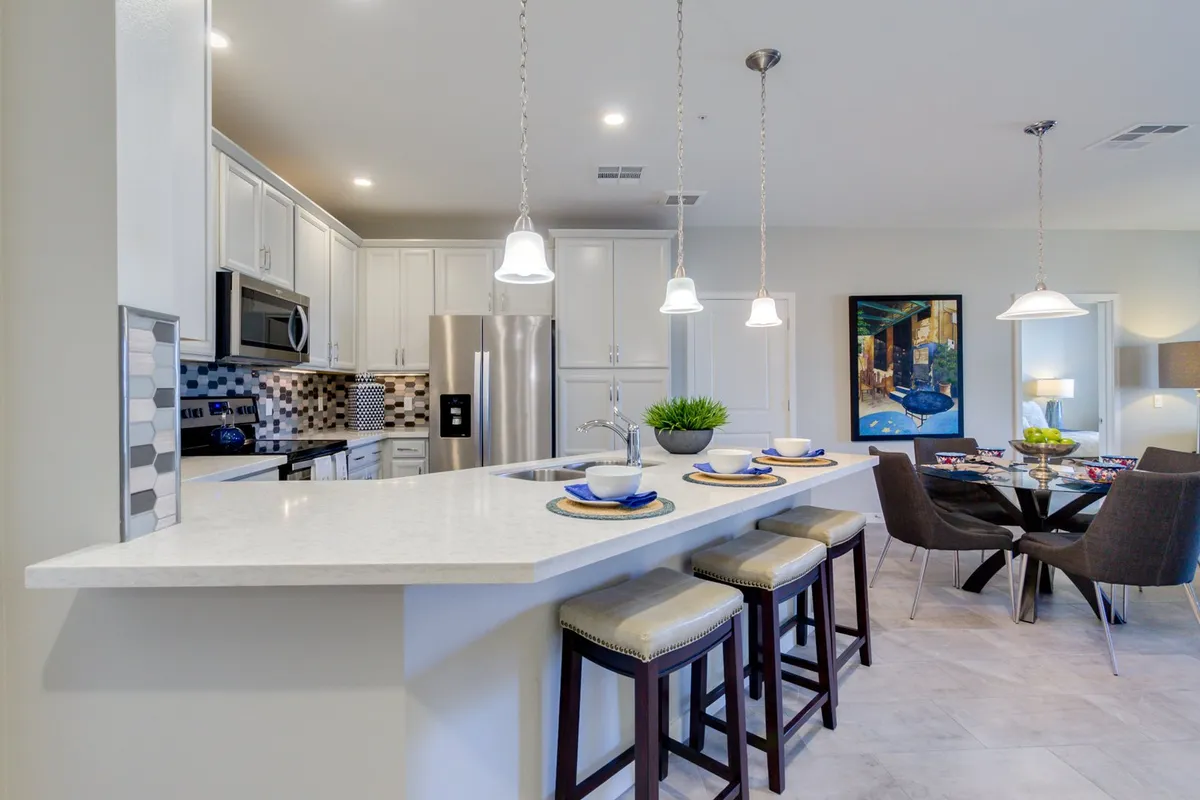 This image features a spacious kitchen with an island countertop and a dining table, enhanced by colorful artwork on the wall. The space is designed for cooking, dining, and entertaining, with a warm, social ambiance that encourages gatherings and shared experiences.